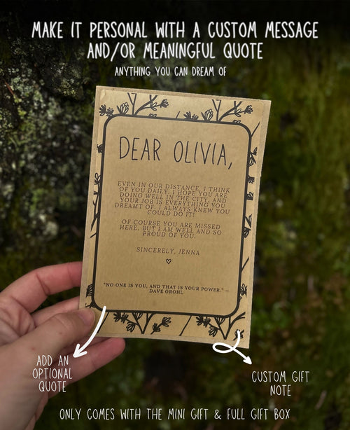 A hand holds a personalized mini gift card with a quote for 'Olivia' against a blurred green outdoor background. White text overlays explain that the card can be personalized with a custom message and quote, and point out features like adding an optional quote and a custom gift note.